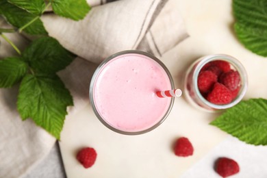 Photo of Glass of tasty raspberry smoothie on light table, flat lay