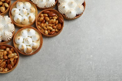 Photo of Many different tartlets on grey table, flat lay with space for text. Delicious dessert