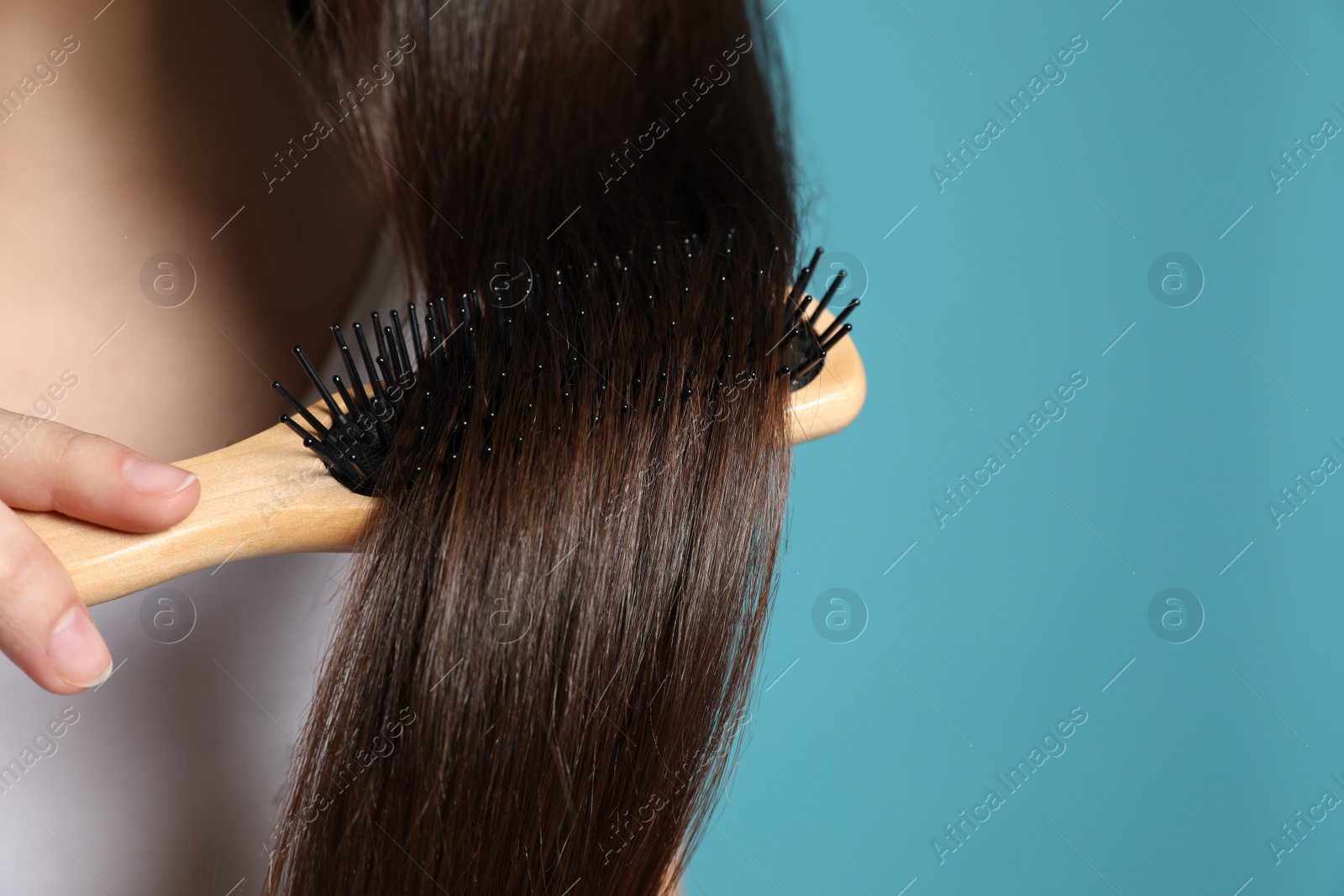 Photo of Woman with hair brush on color background, closeup. Space for text