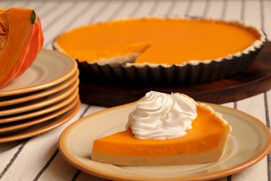 Photo of Piece of fresh homemade pumpkin pie with whipped cream on table