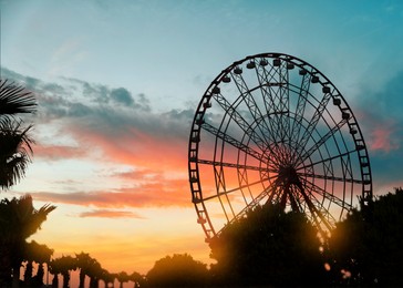 Beautiful large Ferris wheel outdoors at sunset