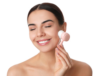 Photo of Young woman using facial cleansing brush on white background. Washing accessory