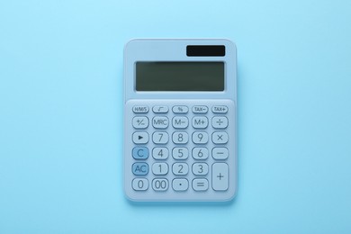 Modern calculator on light blue background, top view