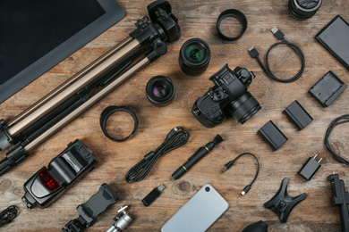 Photo of Flat lay composition with camera and video production equipment on wooden table