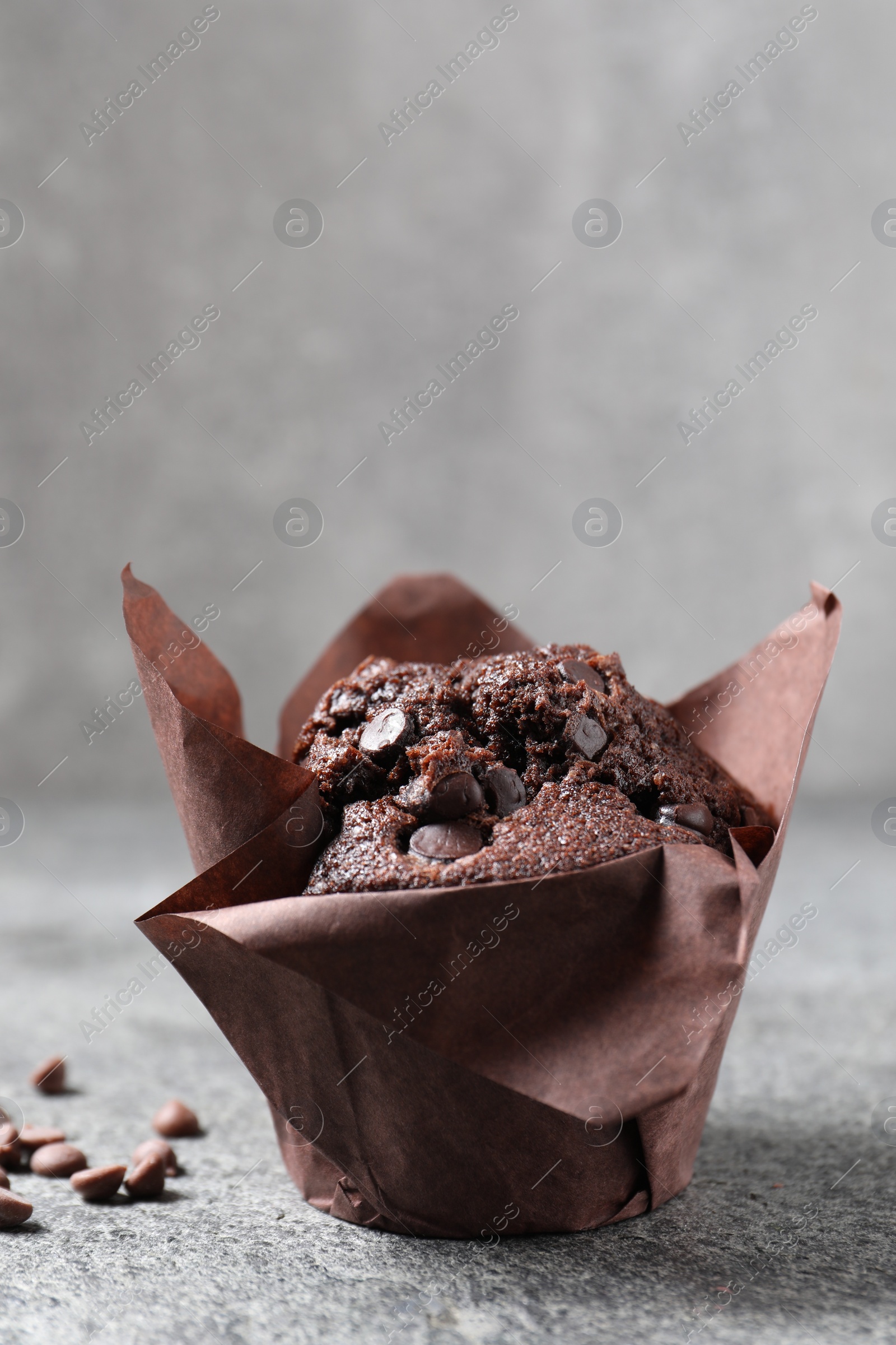 Photo of Tasty chocolate muffin on grey table, closeup