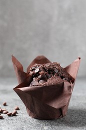 Tasty chocolate muffin on grey table, closeup