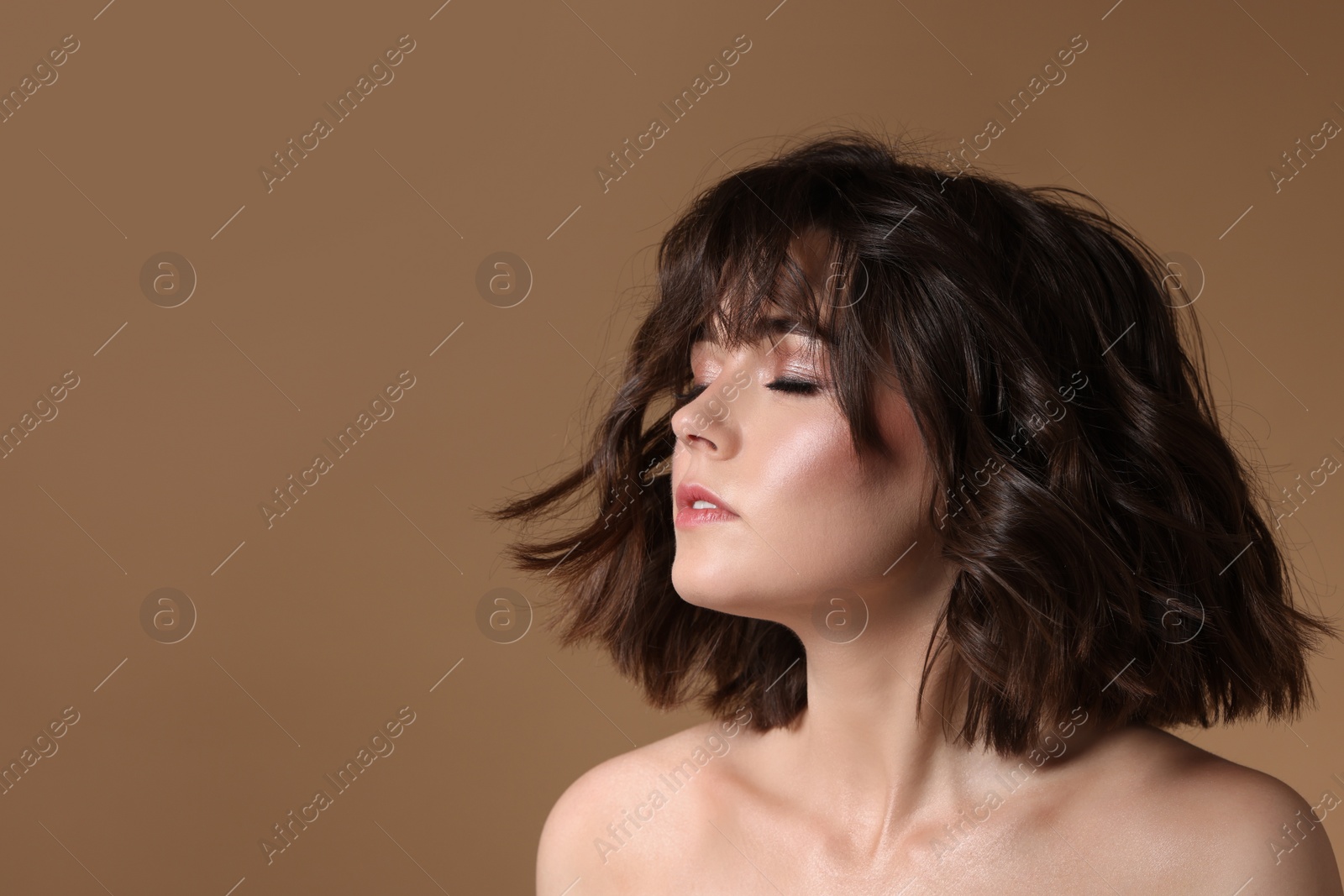 Photo of Portrait of beautiful young woman with wavy hairstyle on brown background. Space for text