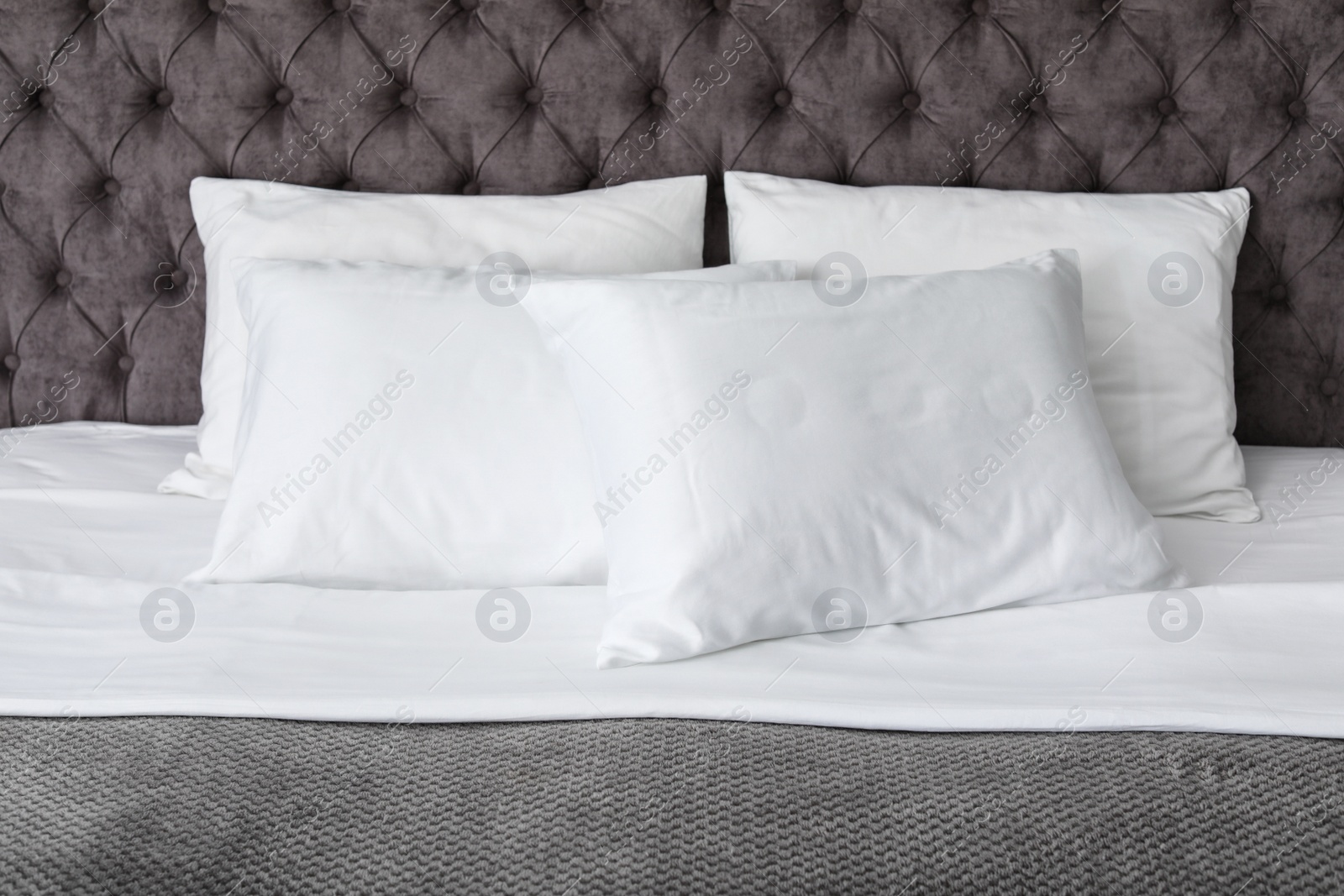 Photo of Soft white pillows on comfortable bed, closeup