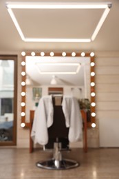 Photo of Blurred viewhairdressing salon with large mirror and chair