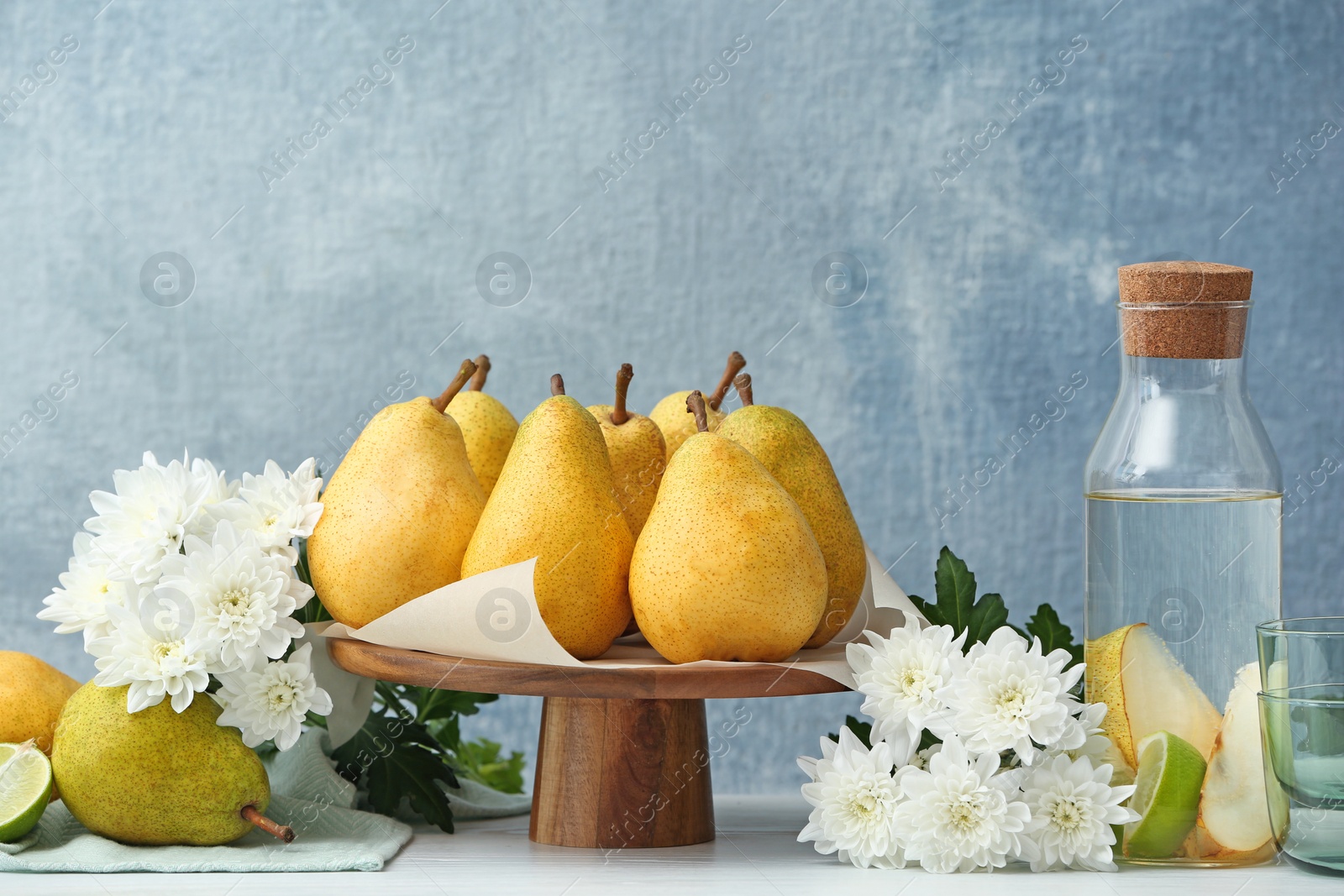 Photo of Stand with fresh ripe pears on table against color background