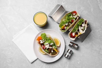 Photo of Delicious fresh vegan tacos served on light grey marble table, flat lay