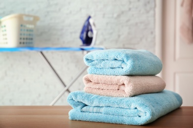 Stack of clean towels on table indoors