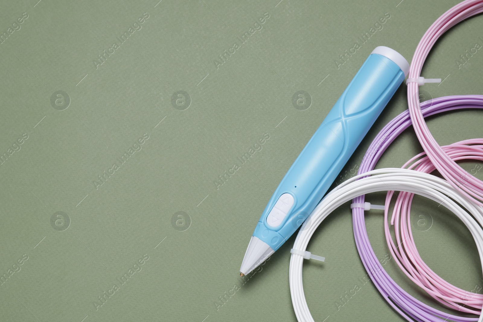 Photo of Stylish 3D pen and colorful plastic filaments on khaki background, flat lay. Space for text