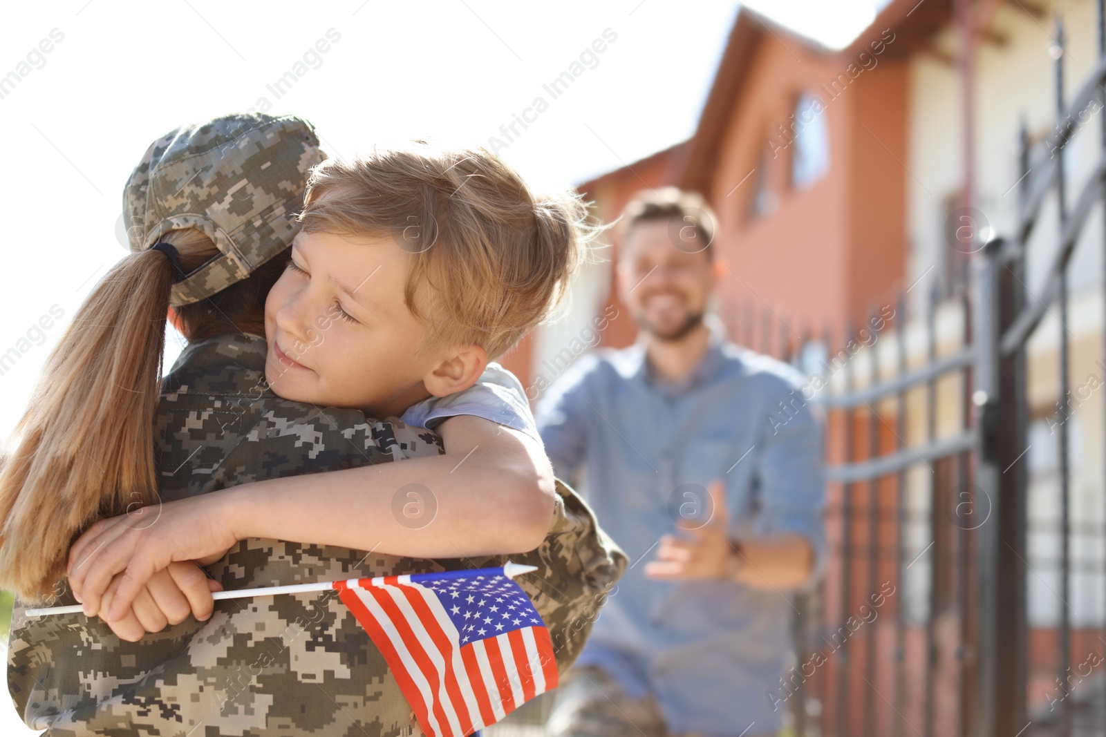 Photo of Female soldier hugging with her son outdoors. Military service