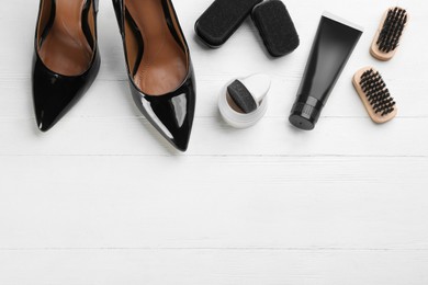 Photo of Flat lay composition with shoe care accessories and footwear on white wooden background. Space for text