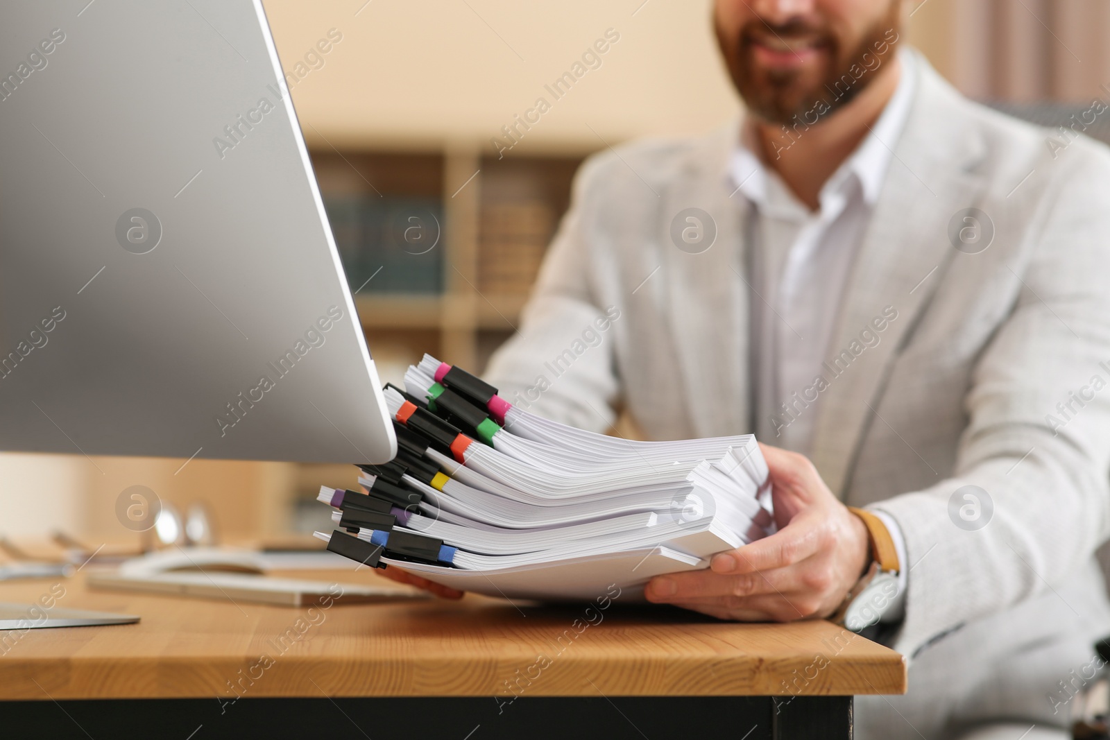 Photo of Businessman with documents at wooden table in office, closeup