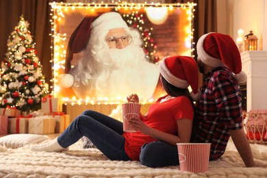 Image of Couple watching movie on projection screen in room decorated for Christmas