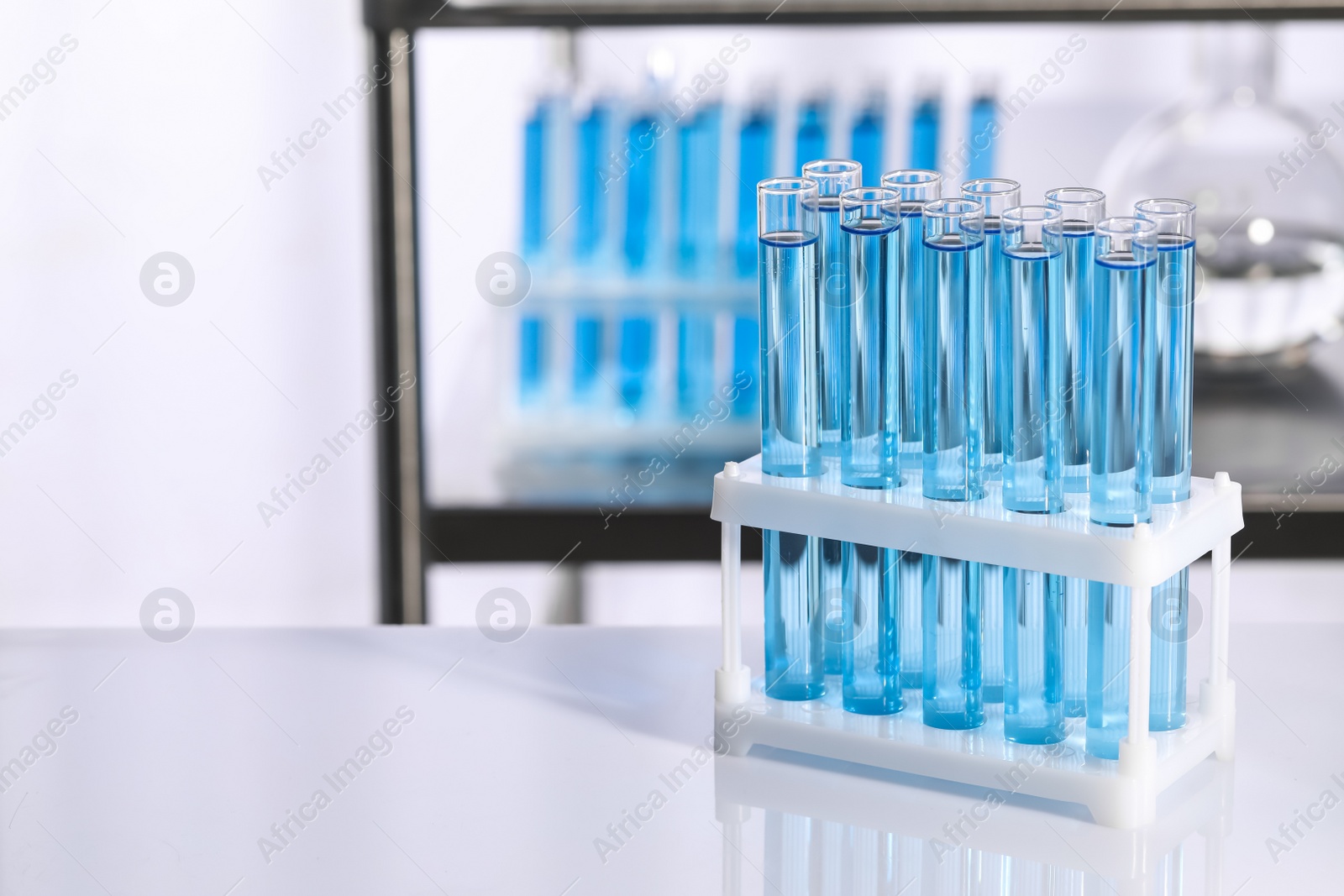 Photo of Test tubes with reagents on table in laboratory, space for text