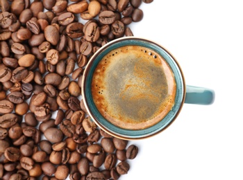 Cup of aromatic hot coffee and beans on white background, top view