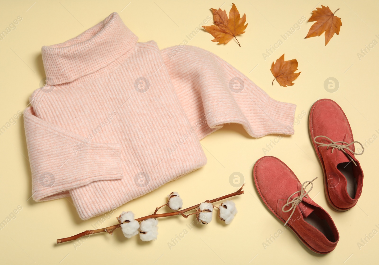 Photo of Flat lay composition with sweater and dry leaves on yellow background. Autumn season