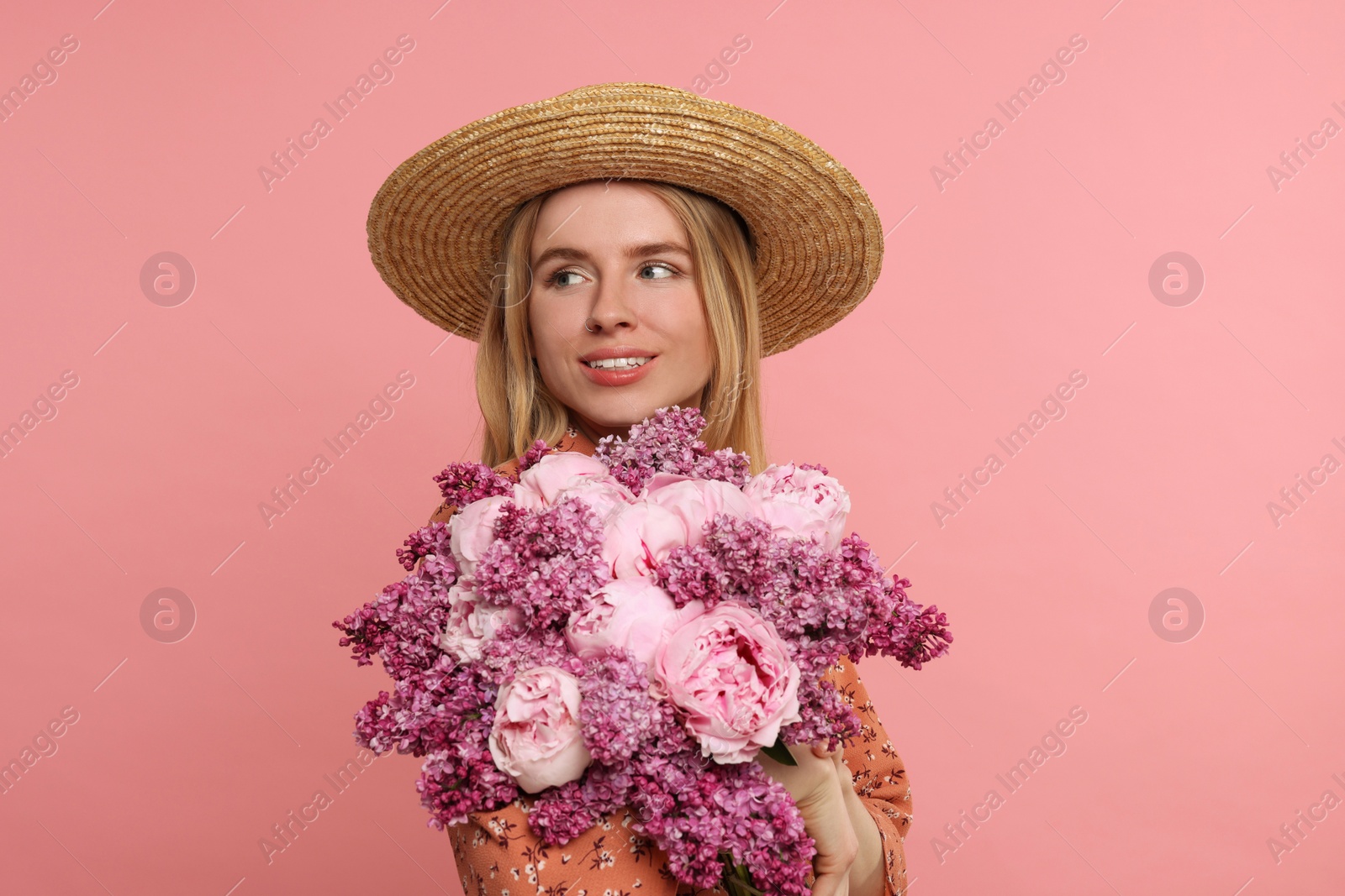 Photo of Beautiful woman with bouquet of spring flowers on pink background