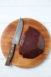 Photo of Piece of raw beef liver and knife on white wooden table, top view