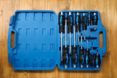 Photo of Set of screwdrivers in open toolbox on wooden table, top view