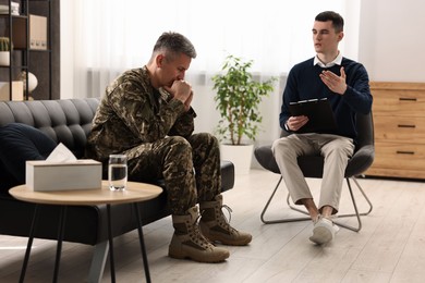 Professional psychotherapist working with military man in office