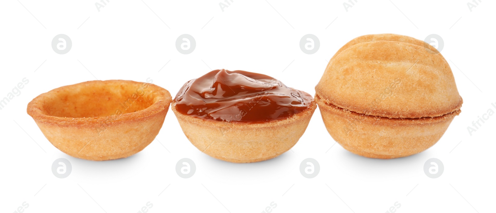 Photo of Delicious nut shaped cookies with boiled condensed milk on white background