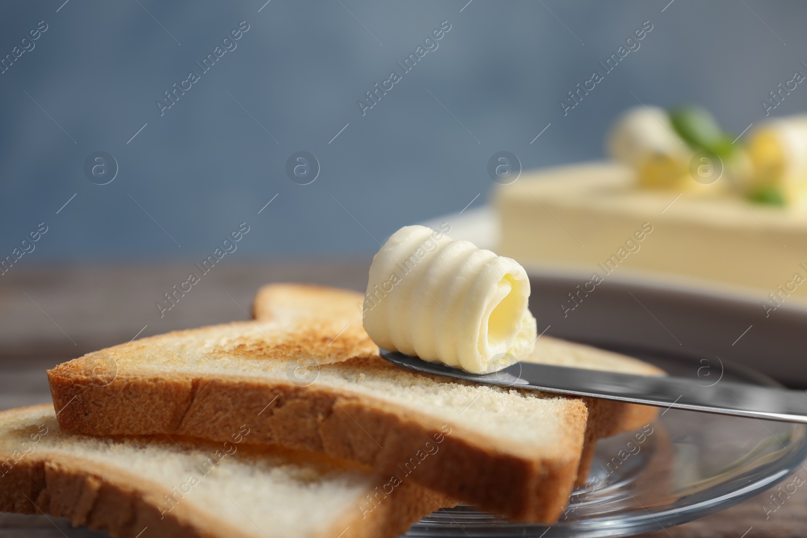 Photo of Toasts with tasty butter curl on plate, closeup