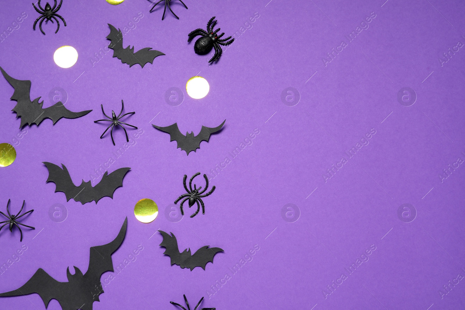 Photo of Flat lay composition with paper bats and spiders on purple background, space for text. Halloween decor