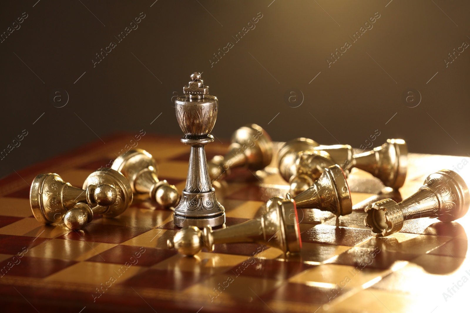 Photo of Chessboard with game pieces on dark background, closeup