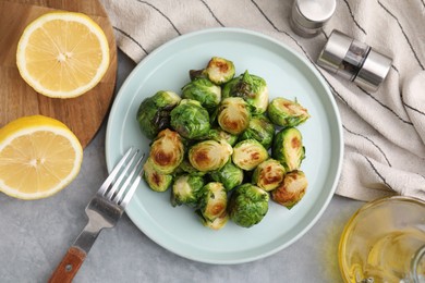 Photo of Delicious roasted Brussels sprouts served on grey table, top view