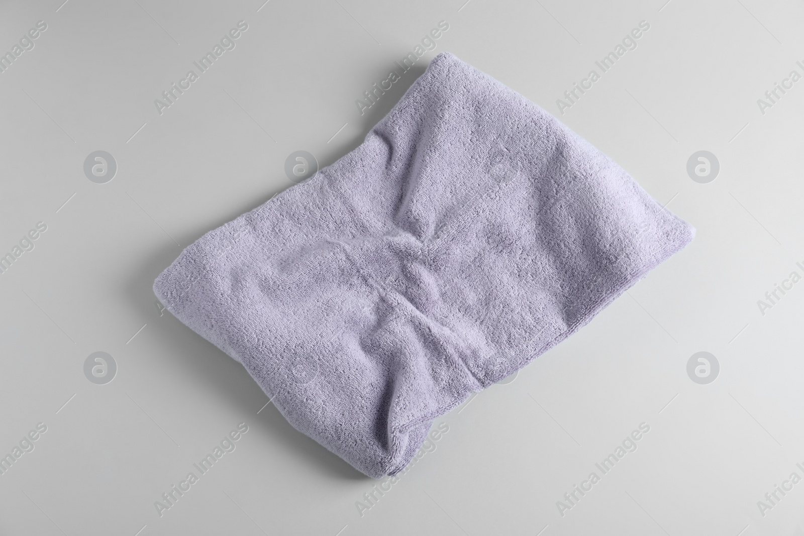 Photo of Fresh fluffy towel on grey background, top view