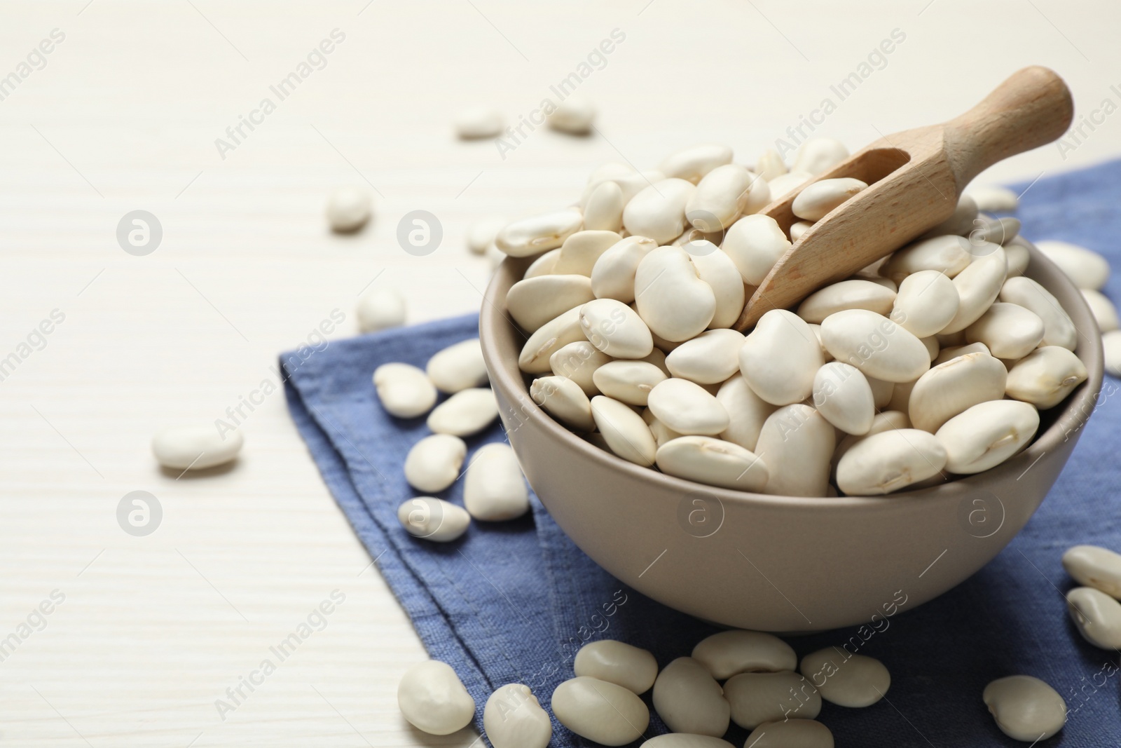 Photo of Raw beans on white wooden table, closeup. Space for text
