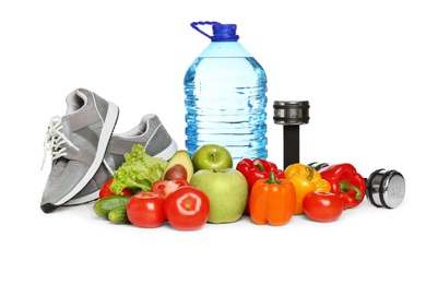 Photo of Healthy food, dumbbells and sneakers on white background. Concept of weight loss