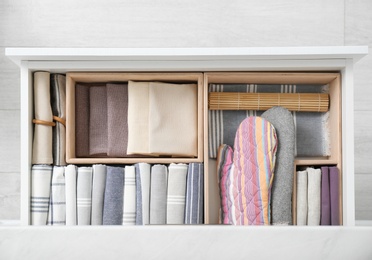 Photo of Open drawer with different textiles in kitchen, top view