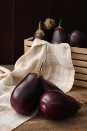 Many raw ripe eggplants on wooden table