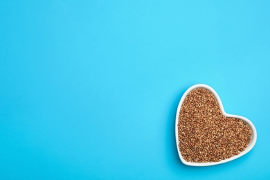 Photo of Buckwheat grains on light blue background, top view. Space for text