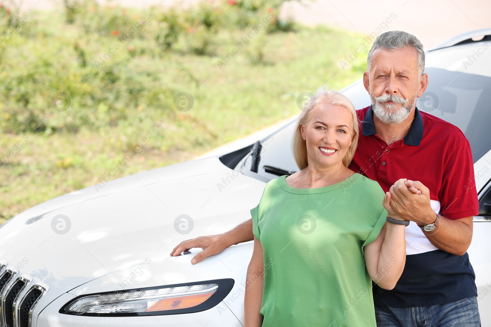 Photo of Happy senior couple standing near car outdoors