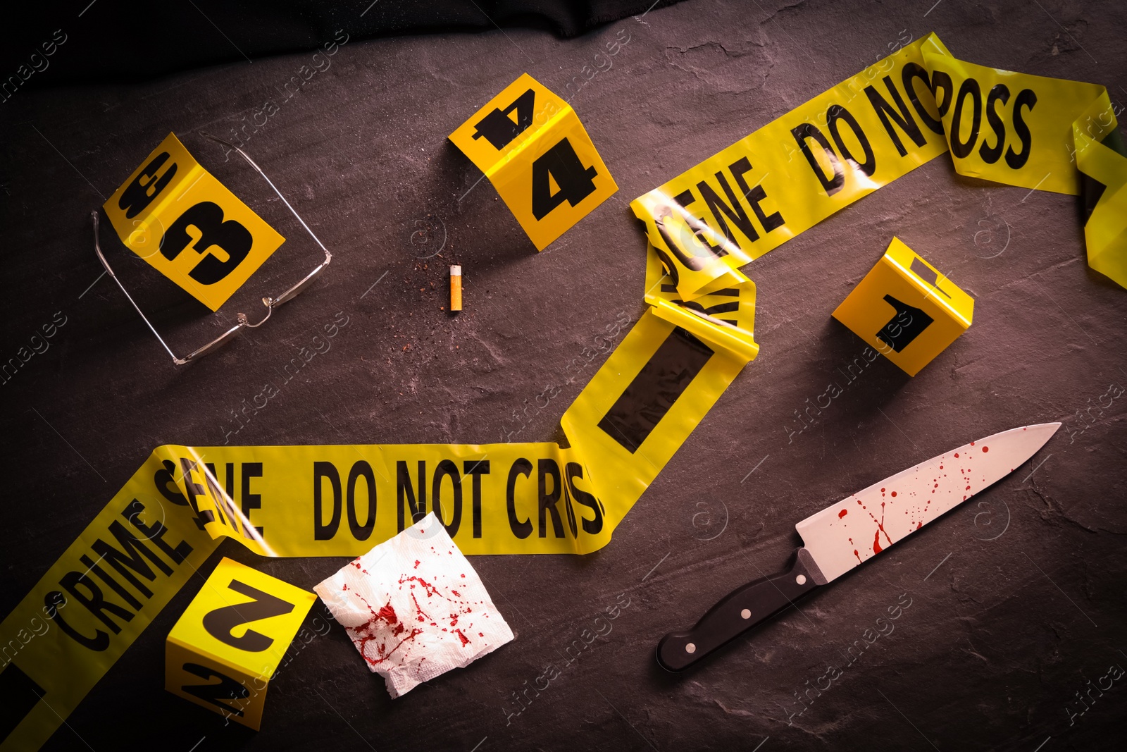 Photo of Flat lay composition with evidences and crime scene markers on black background