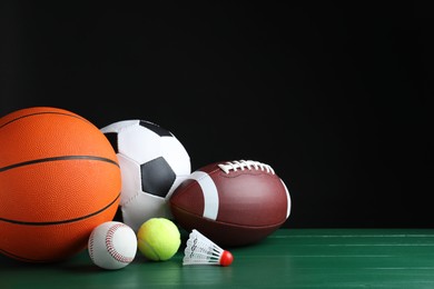 Set of different sport balls and shuttlecock on green wooden surface. Space for text