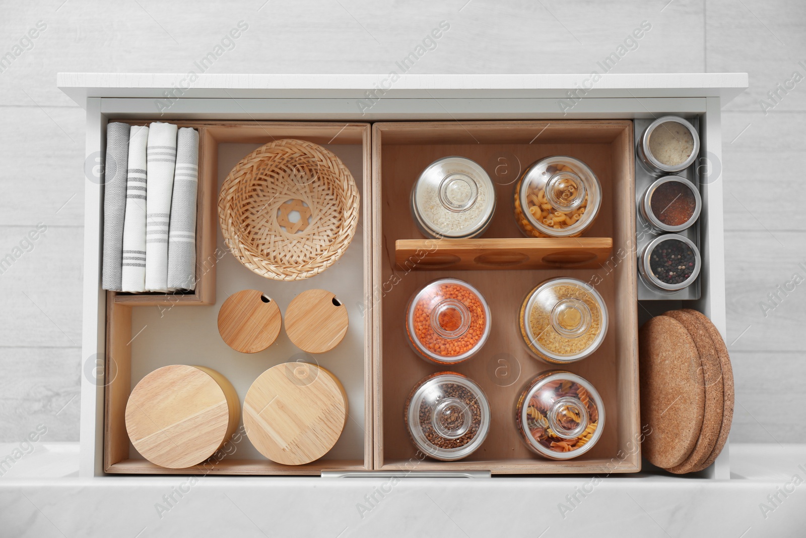 Photo of Open drawer with different jars indoors, top view. Order in kitchen