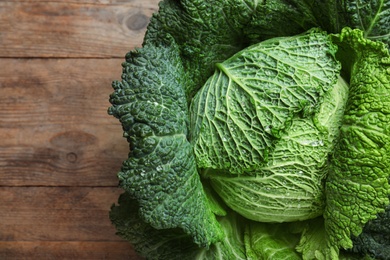 Fresh ripe savoy cabbage on wooden table, top view