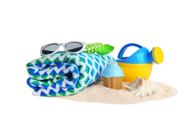 Photo of Set of plastic beach toys, towel, sunglasses and pile of sand on white background