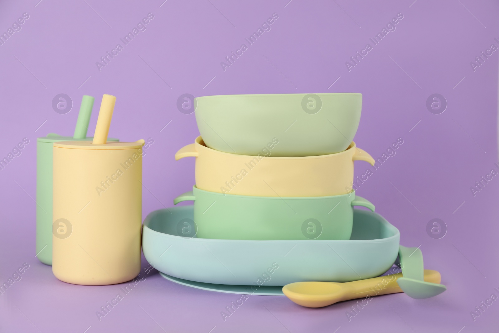 Photo of Set of plastic dishware on violet background. Serving baby food