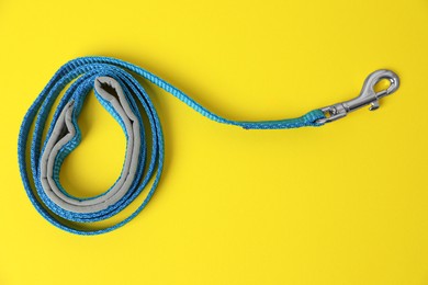 Blue dog leash on yellow background, top view