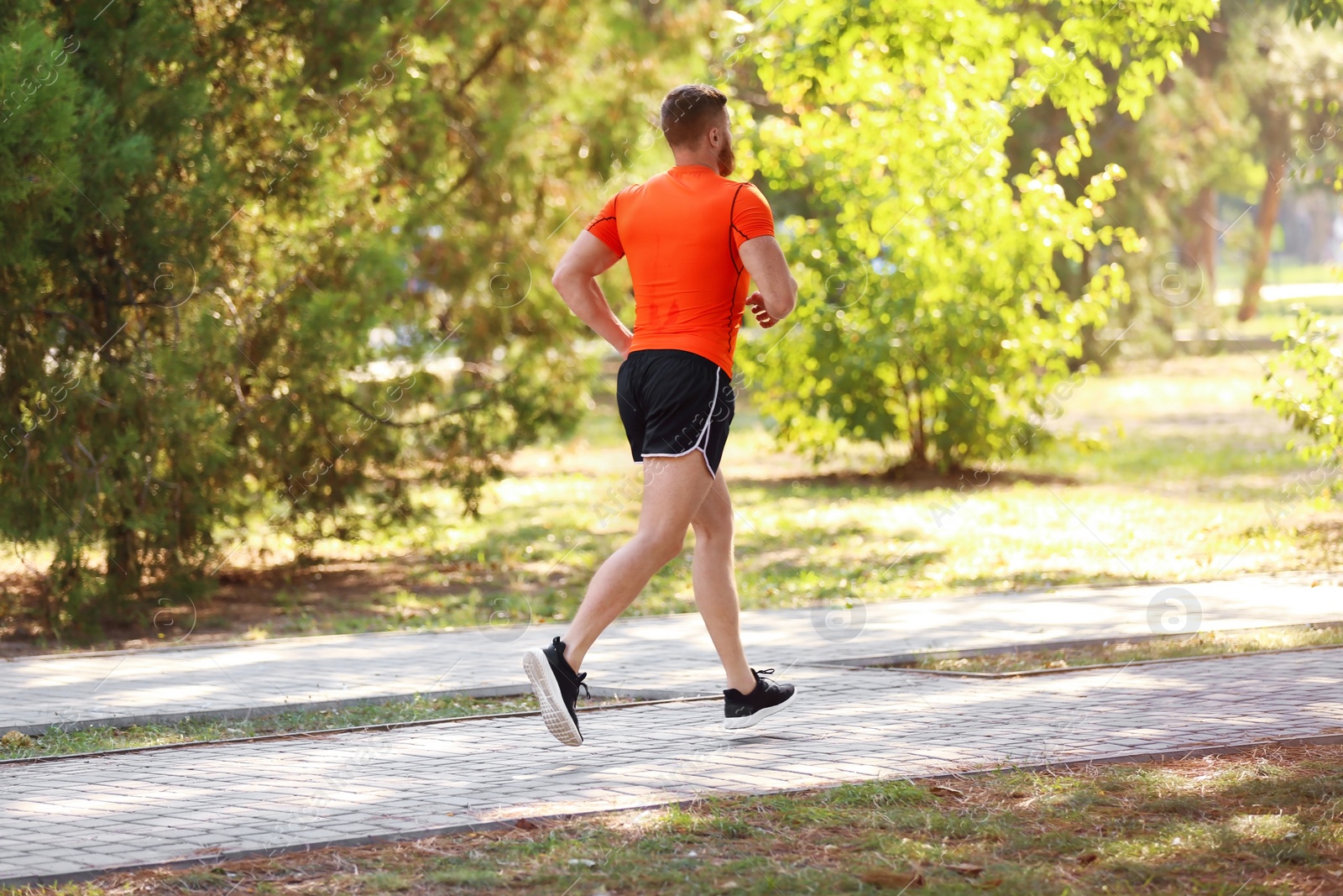 Photo of Young man running in park on sunny day