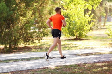 Young man running in park on sunny day