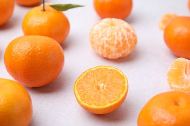 Photo of Fresh juicy tangerines on light grey table, closeup. Space for text